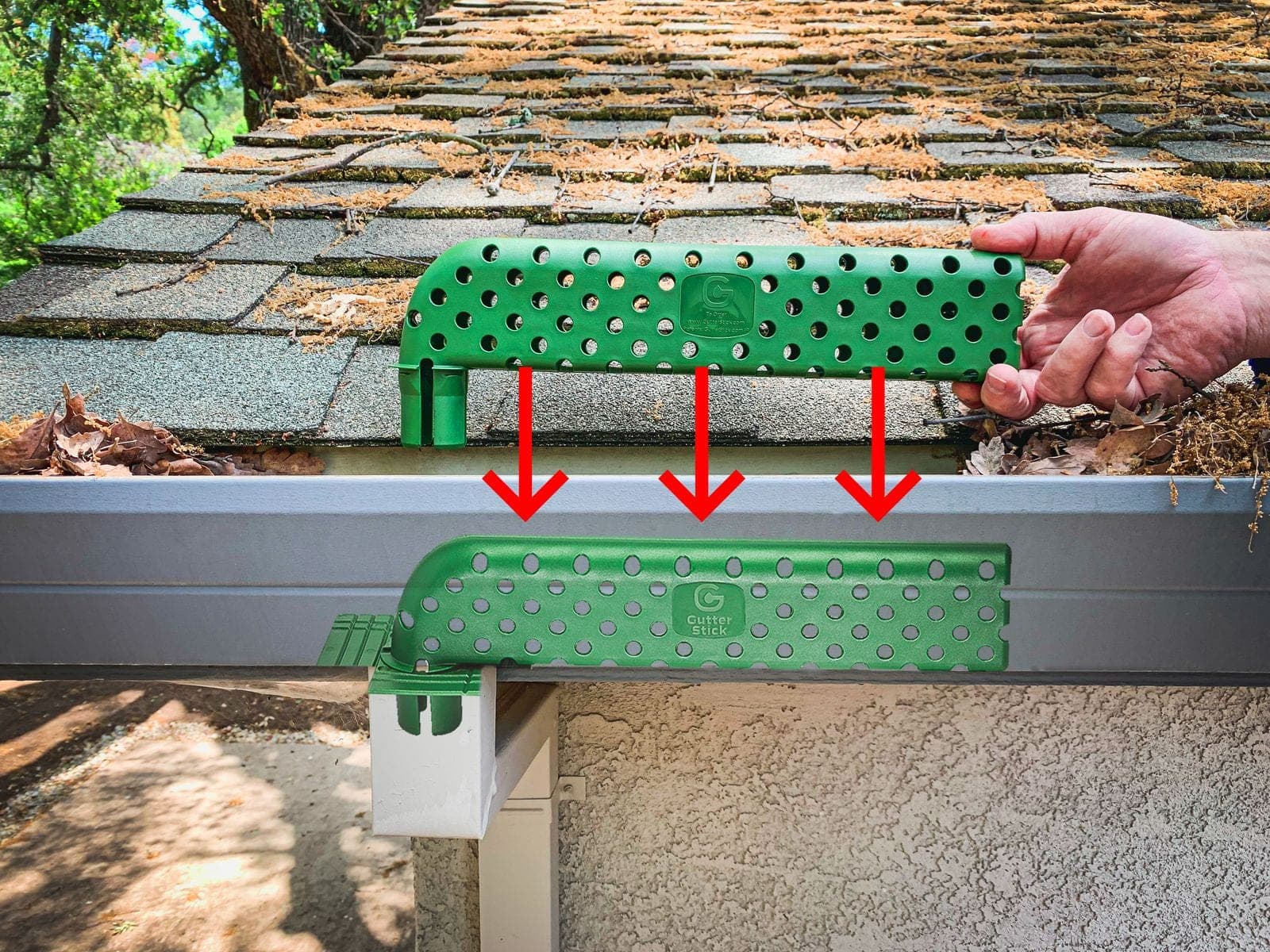 The Gutter Stick manufacturer's promotional image showing the perforated insert being placed into a gutter over the downspout opening