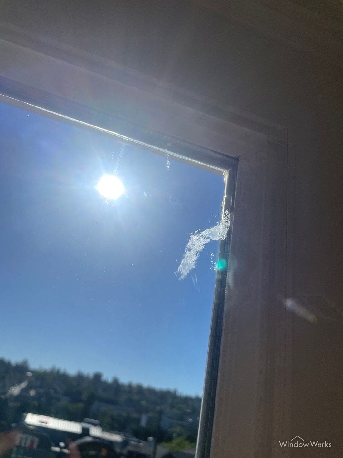 A smear of cured caulk on window glass beside the frame.