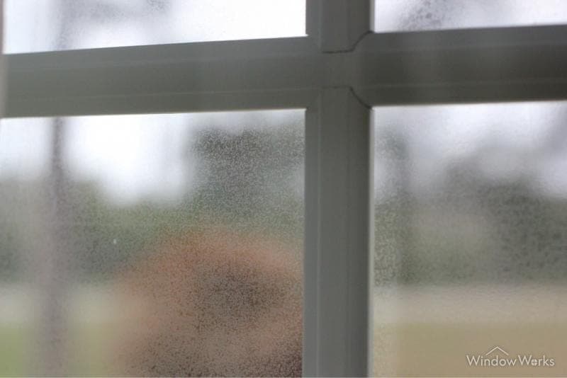 Permanent etching clouding the surface of a window pane.