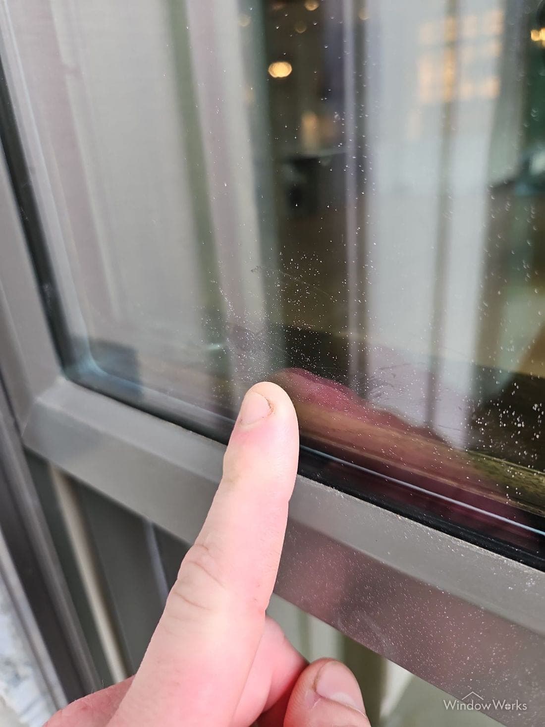 Fine paint overspray speckled across a window pane.