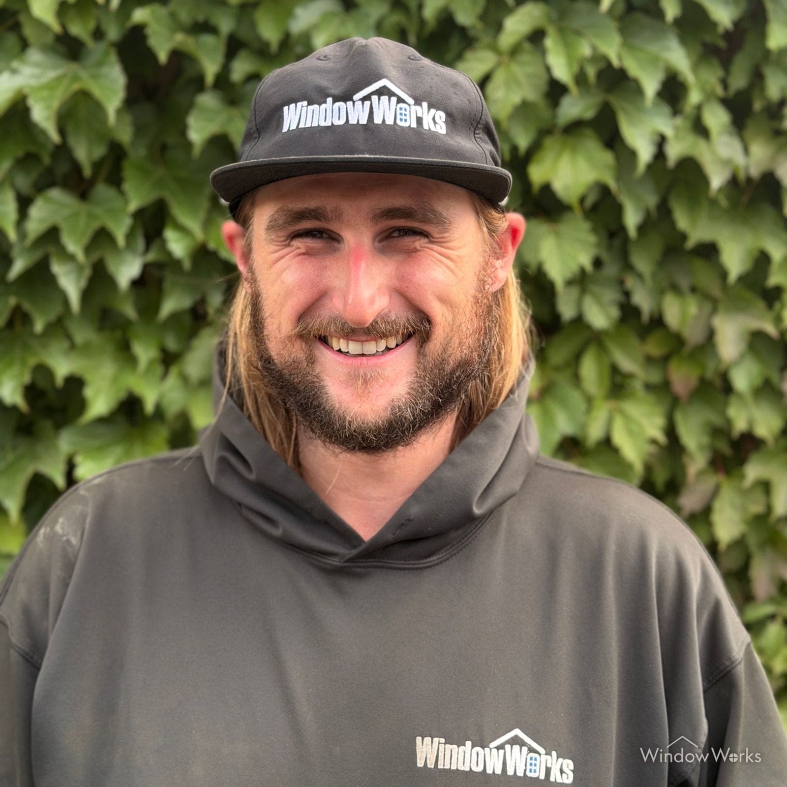 Connor Kraft, General Manager at WindowWorks, in uniform in front of an ivy wall