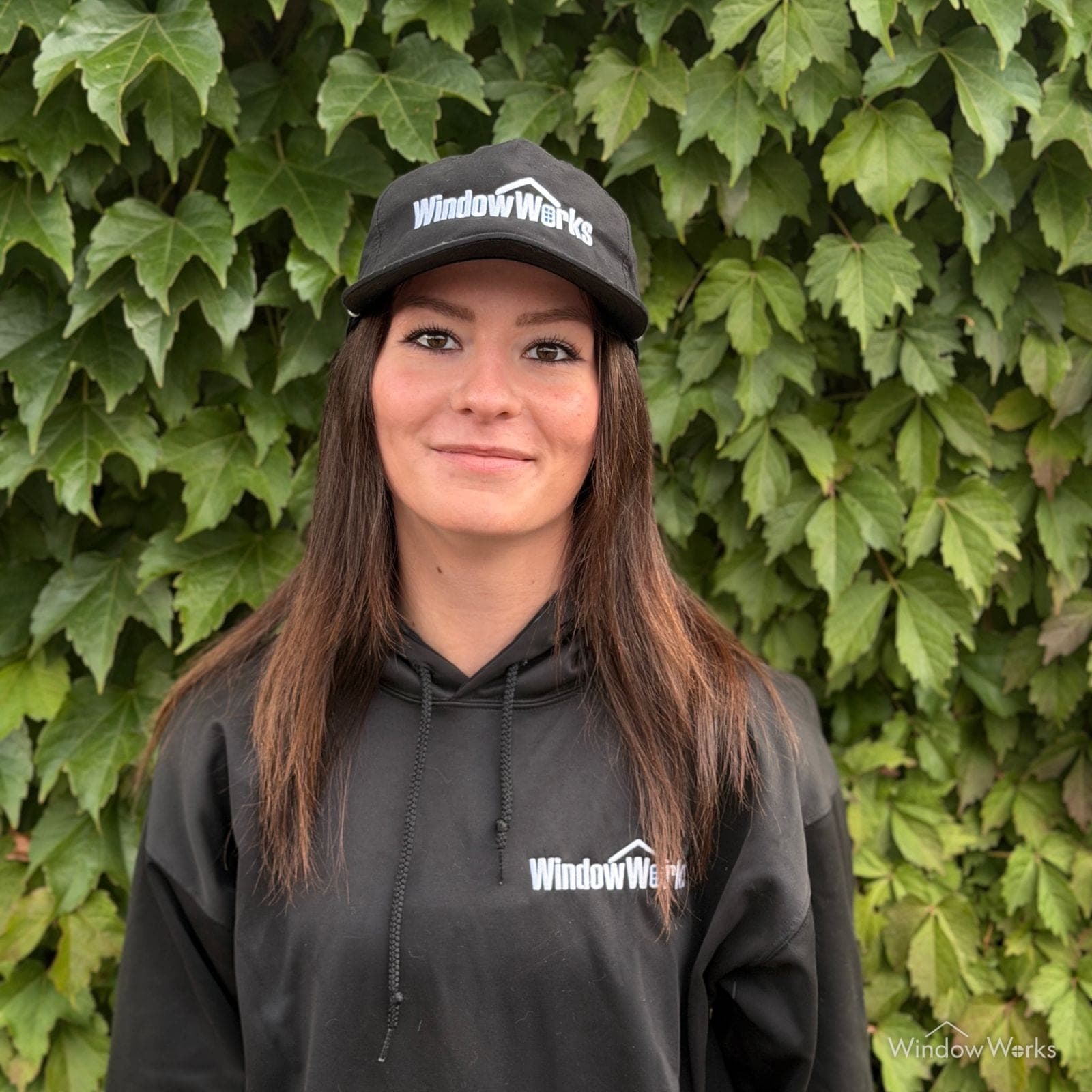 Emily G., Field Lead at WindowWorks, in uniform in front of an ivy wall