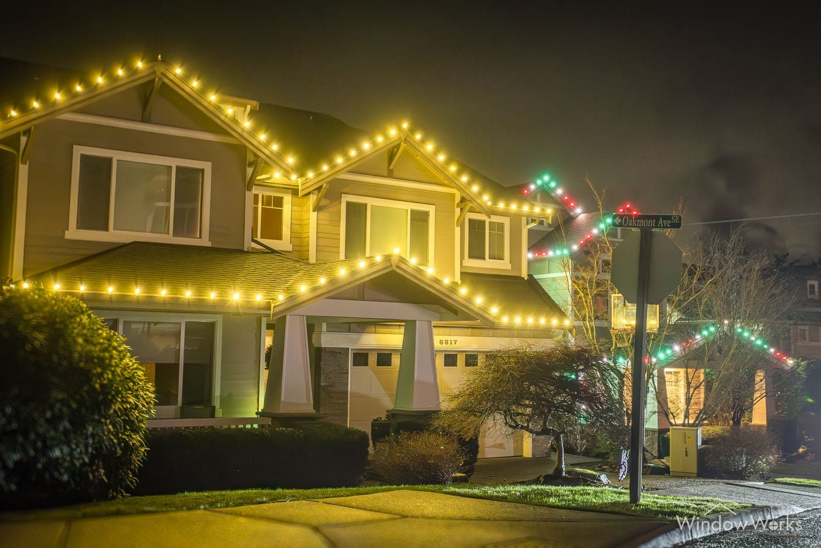 Two homes in warm white and red bulbs on a foggy night.