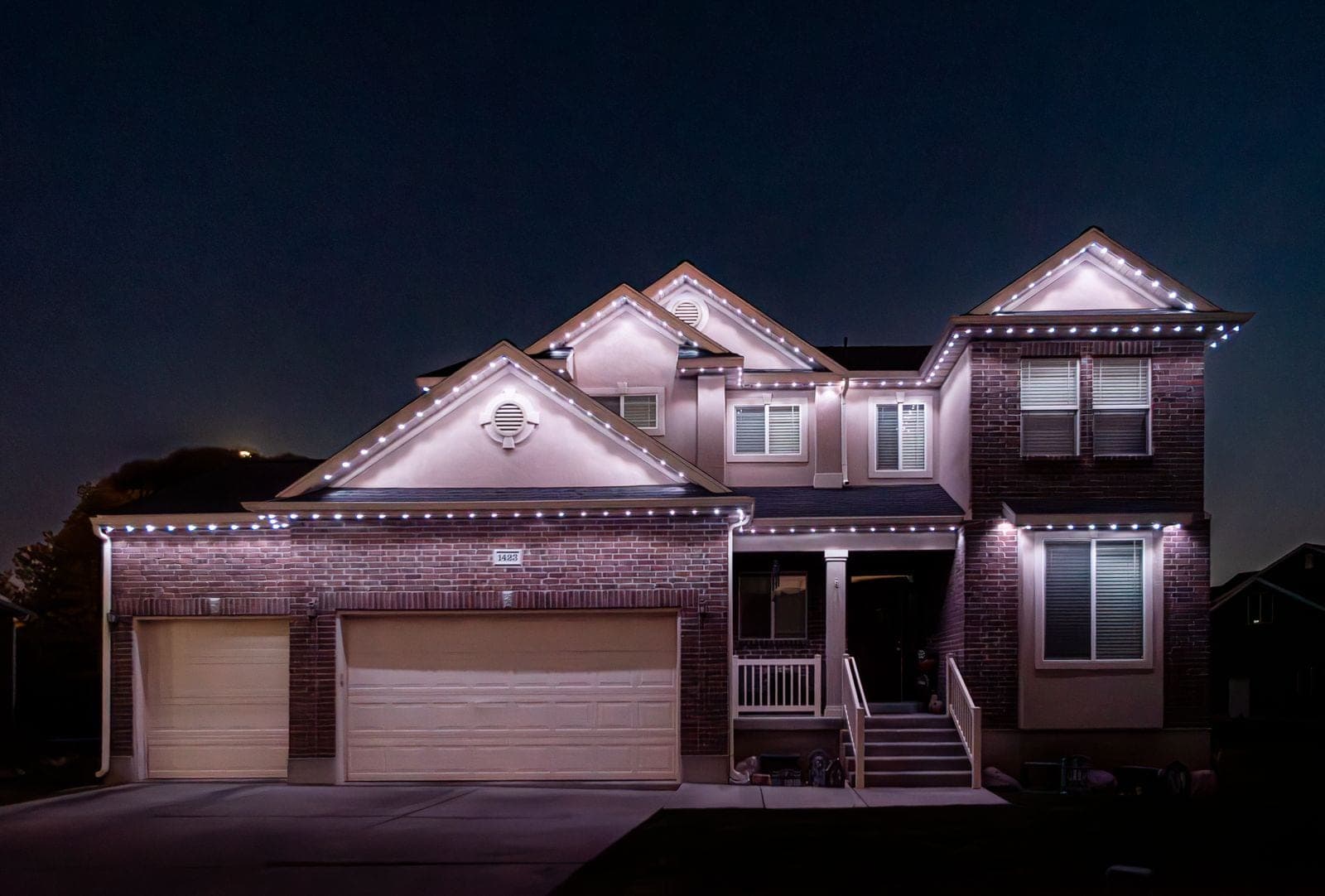 The same home running plain warm white on every roofline, the everyday setting with no color at all.