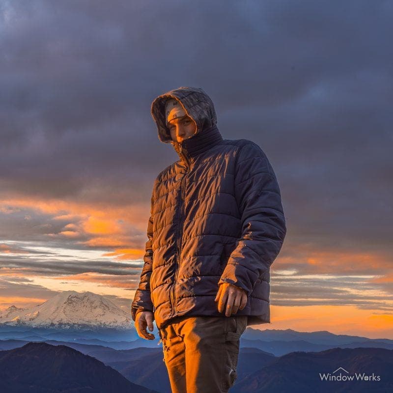Jake D. of WindowWorks standing on a mountain summit at sunset