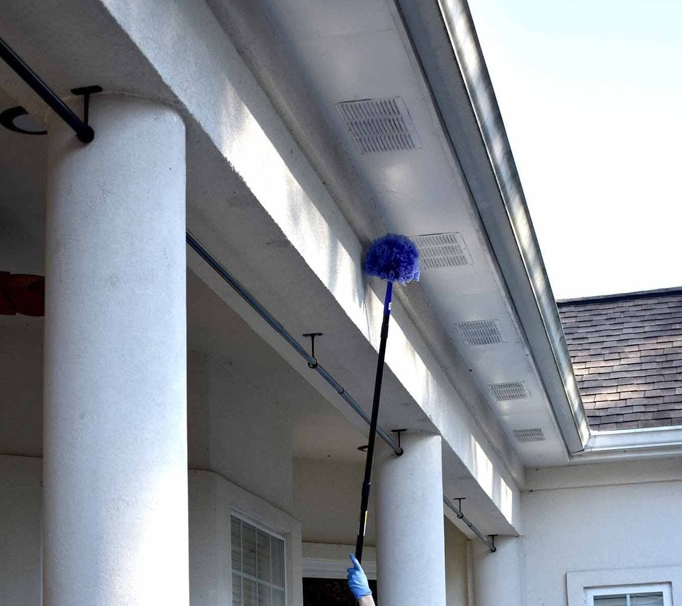 Clearing cobwebs from a high exterior eave with extension tooling