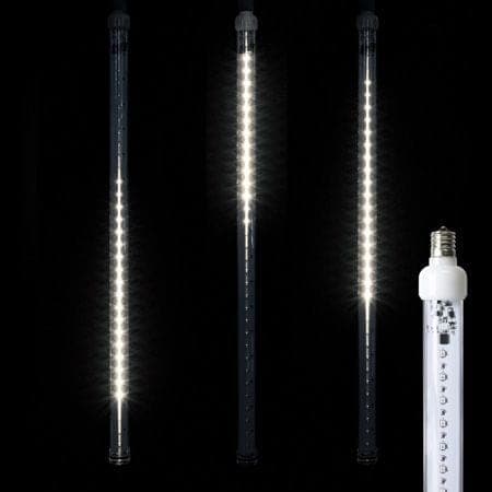 Three snowfall tubes mid-cascade, streaks of white light falling down each.