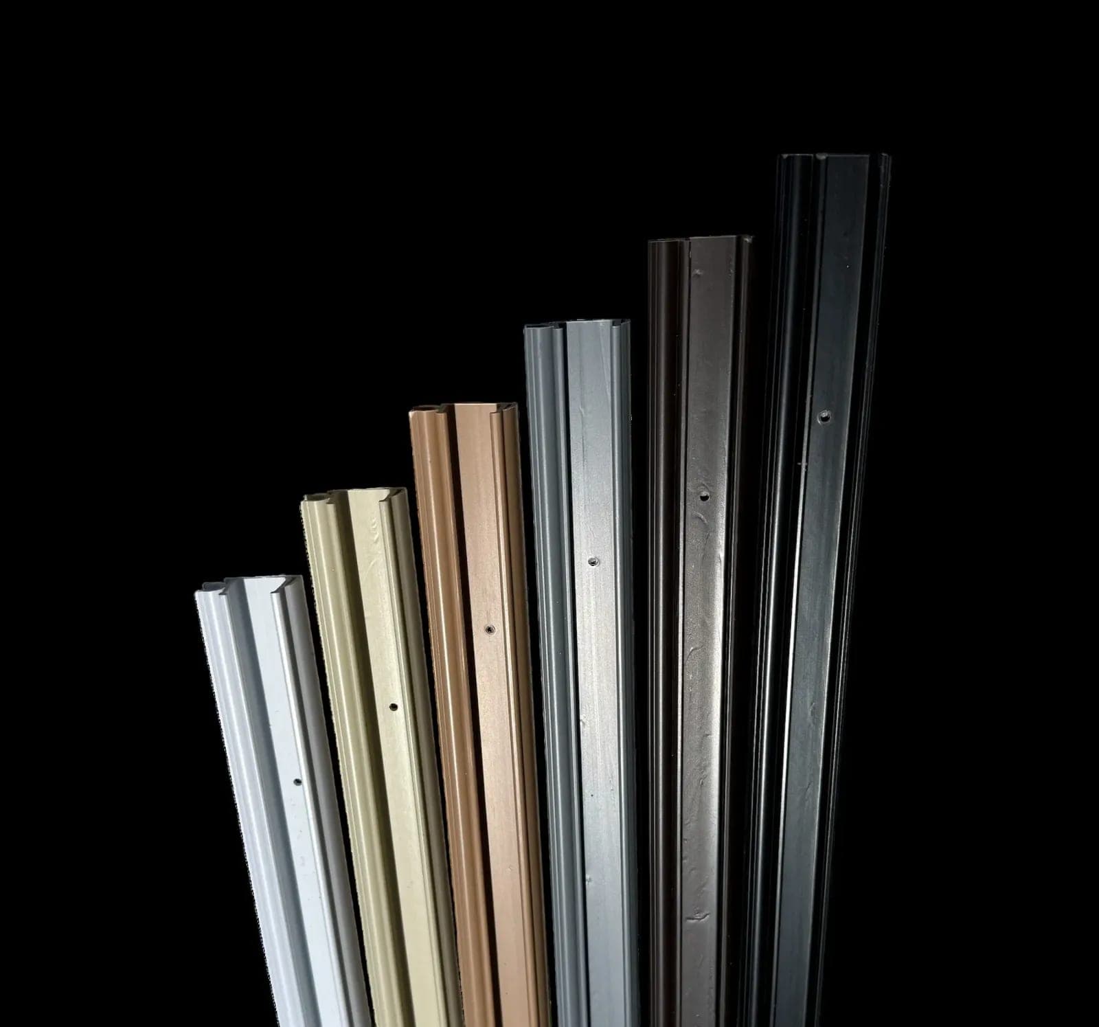 A fan of aluminum track extrusions in bronze, copper, white, black, gray and clear finishes.
