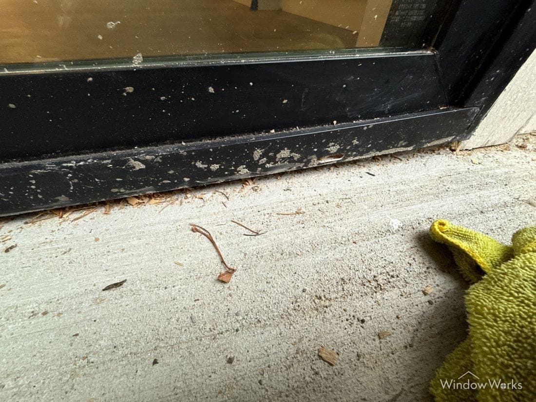 Concrete splatter across the frame and threshold of a sliding glass door.