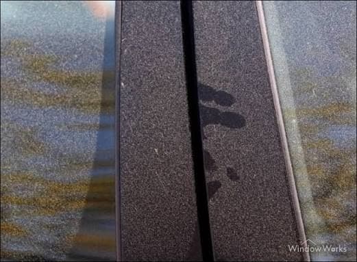 Heavy spring pollen coating glass and dark trim, with swipe marks showing the surface underneath.