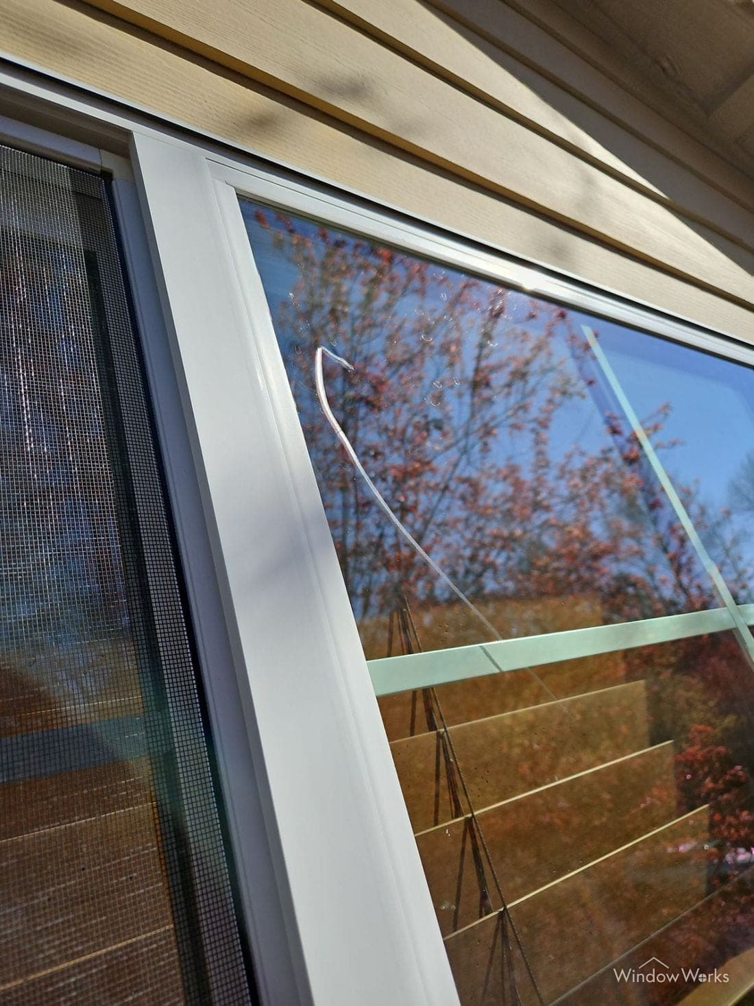A long curved scratch in a window pane, visible against the sky.