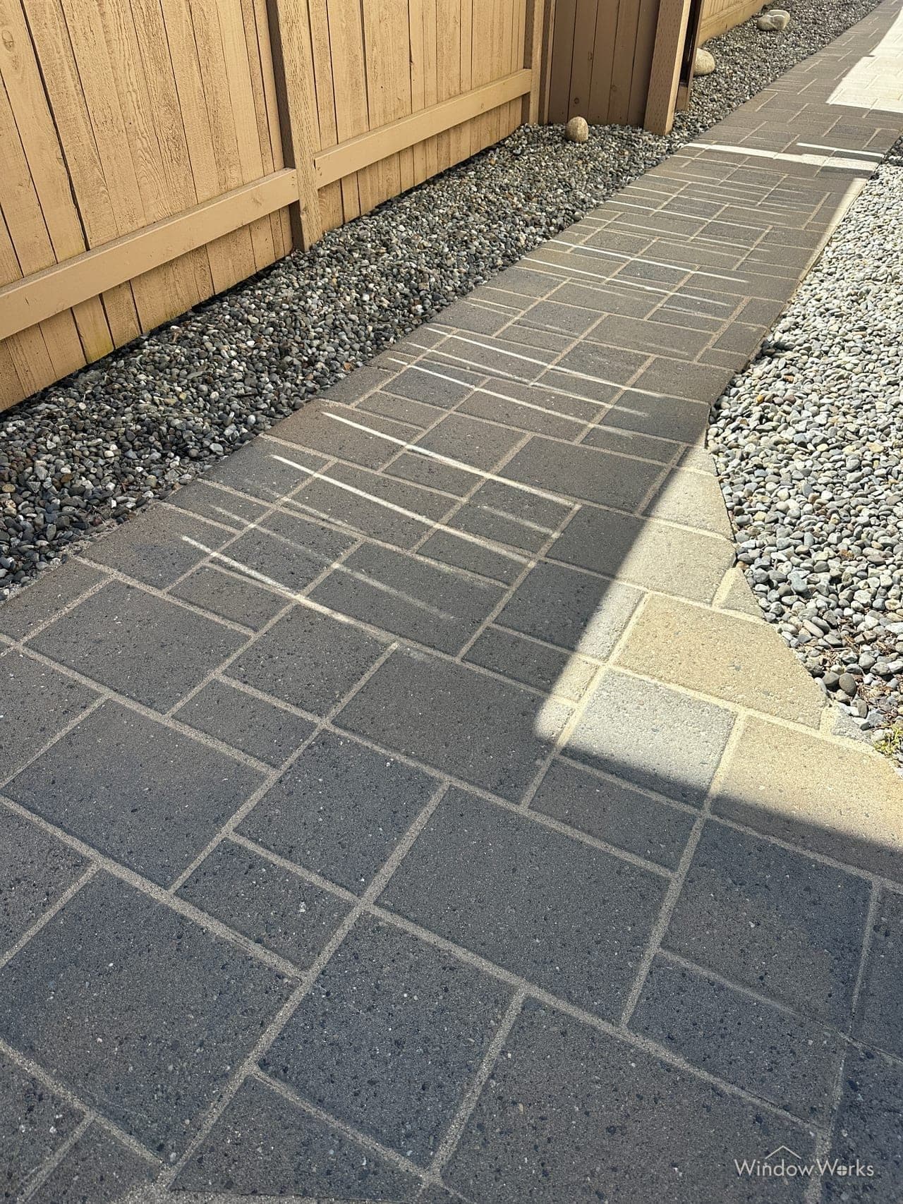 WindowWorks restoring grimy pavers, a clean swath cutting through the dirt mid-job on the Eastside