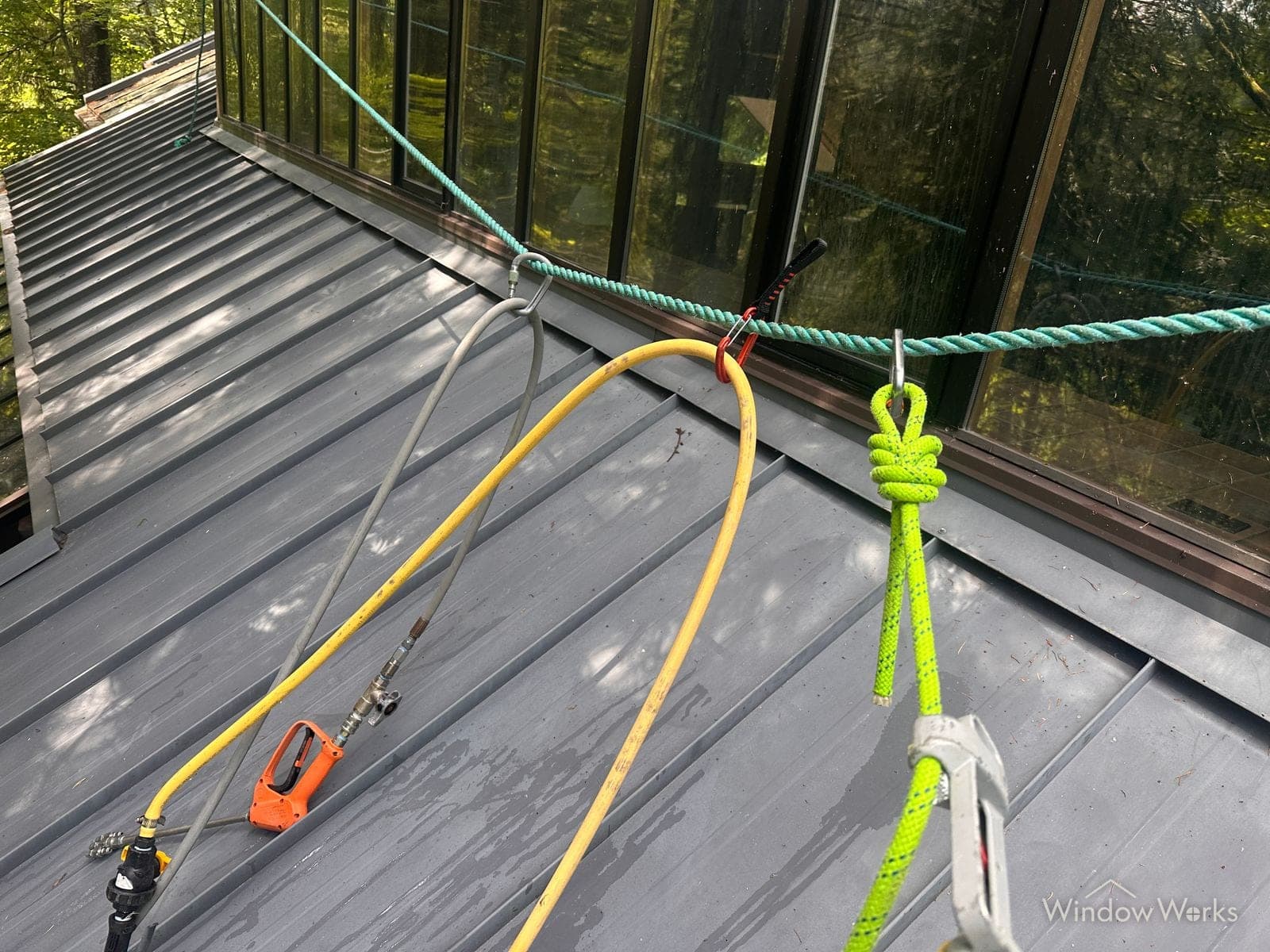 Rope and rigging anchored on a steep roof for fall protection during a WindowWorks roof cleaning