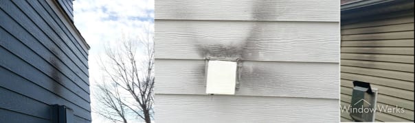 Soot and smoke staining on siding around a vent